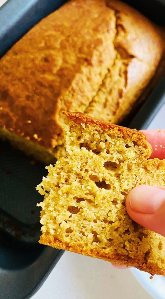 Spelt lemon cake with a golden crust, sliced to reveal its moist, fluffy texture