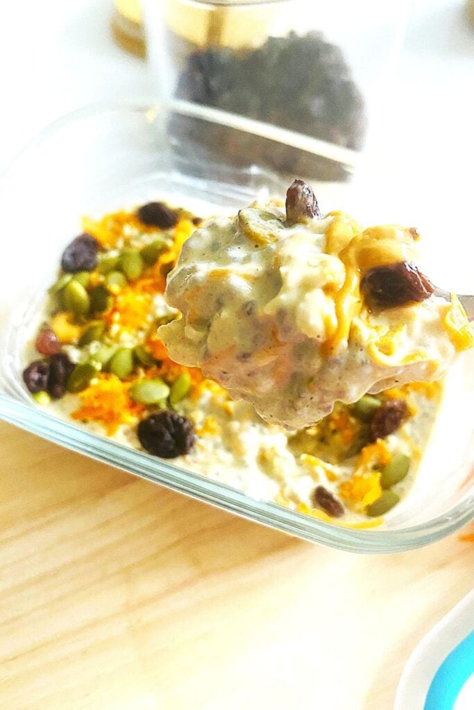 Close-up of creamy carrot cake overnight oats in a jar with peanut butter, chia seeds, and a sprinkle of cinnamon."