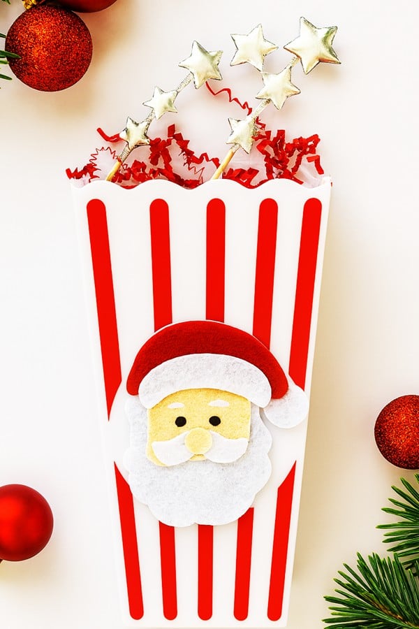 Decorated popcorn bags with Santa faces and ribbon bows for a Secret Santa activity