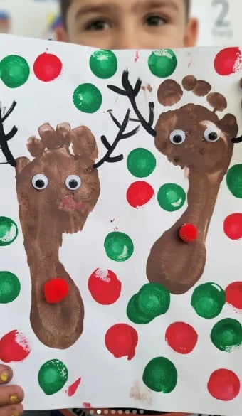 Painted footprint reindeer with antlers, googly eyes, and red pom-pom noses