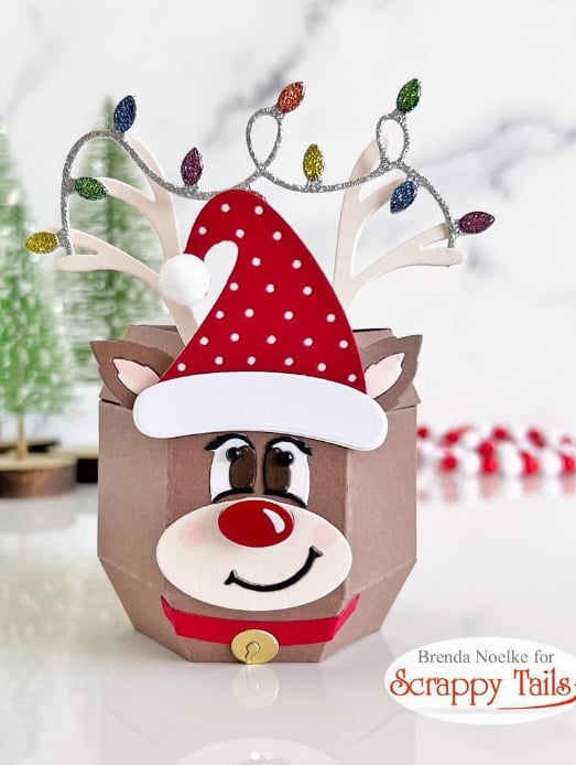 Reindeer gift box with a Santa hat, smiling face, and Christmas light antlers